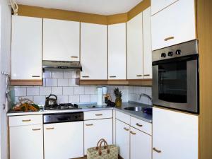 una cocina blanca con armarios blancos y fregadero en Holiday Home Bungalowpark Landsrade-1 by Interhome, en Gulpen