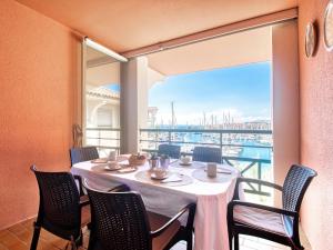 een eetkamer met een tafel en stoelen en een groot raam bij Apartment Bleu Marine-6 by Interhome in Fréjus