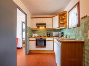 濱海卡瓦萊爾的住宿－Apartment Les Arbousiers-1 by Interhome，一间厨房,配有白色家电和绿色瓷砖
