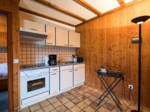 una cocina con electrodomésticos blancos y una mesa. en Apartment Reinskopf-1 by Interhome en Schönecken