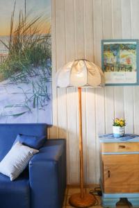 オッテルンドルフにあるHoliday Home Achtern Diek by Interhomeの青いソファの横に座る床灯