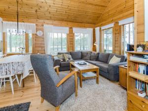 a living room with a couch and a table at Holiday Home Sammonranta by Interhome in Kolinkylä