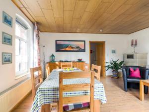 a dining room with a table and a couch at Apartment von Dollen-2 by Interhome in Oberndorf +26 photos