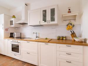 a kitchen with white cabinets and a wooden counter top at Holiday Home Casa di Nonno by Interhome in Cividale del Friuli +27 photos