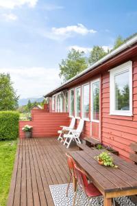eine Holzterrasse mit Stühlen und einem Tisch auf einem Haus in der Unterkunft Holiday Home Pernilles hytte - FJS284 by Interhome in Kyrkjebø
