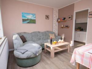 een woonkamer met een bank en een tafel bij Apartment Nordstrand by Interhome in Norddeich