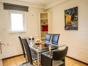 a dining room with a glass table and chairs at Holiday Home Bungalowpark Landsrade by Interhome in Gulpen