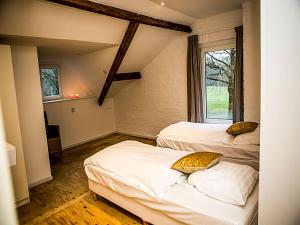 a room with two beds and a window at Holiday Home Bungalowpark Landsrade by Interhome in Gulpen +22 photos