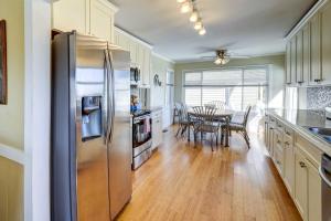 a kitchen with a stainless steel refrigerator and a table at Ocean Isle Beach Home with Canal Views! in Ocean Isle Beach