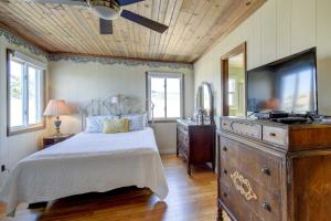a bedroom with a bed and a dresser with a television at Ocean Isle Beach Home with Canal Views! in Ocean Isle Beach