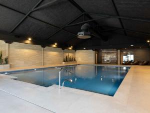 a large swimming pool in a large building at Holiday Home Citta Romana-1 by Interhome in Hellevoetsluis +11 photos