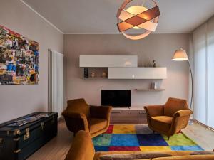 a living room with two chairs and a tv at Villa Giuseppina by Interhome in Besozzo