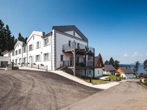 a large white building on the side of a road at Studio Lakeside Village 2 by Interhome in Frymburk