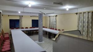 a conference room with a row of tables and chairs at Lovely 5-Bed Room House With a swimming Pool in Diani Beach