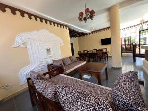 a living room with a couch and a table at Lovely 5-Bed Room House With a swimming Pool in Diani Beach