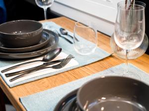 a wooden table with plates and glasses on top of it at Holiday Home Tiny Haus Westerwald 16 Red by Interhome in Bad Marienberg