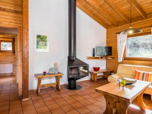 a living room with a fireplace in a log cabin at Holiday Home Reinskopf-3 by Interhome in Schönecken