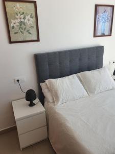 a bedroom with a bed with a blue headboard and a night stand at Apartment Mojon Hills in Isla Plana