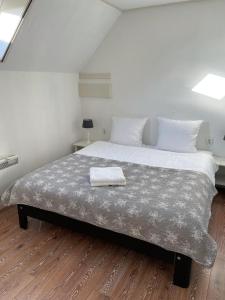 een slaapkamer met een groot bed met een deken erop bij T'hûs bed & breakfast in Katlijk