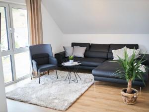 a living room with a black leather couch and two chairs at Apartment Landliebe by Interhome 