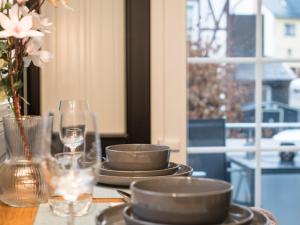 una mesa con platos y copas de vino y una ventana en Holiday Home Tiny Haus Westerwald 16 Green by Interhome, en Bad Marienberg