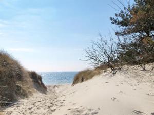 a beach with footprints in the sand and the ocean at Holiday Home Elona - 950m from the sea in Bornholm by Interhome in Vester Sømarken