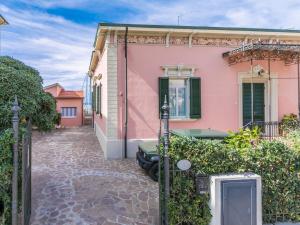 a pink house with a car parked in front of it at Apartment Ponente N-2 by Interhome in San Vincenzo