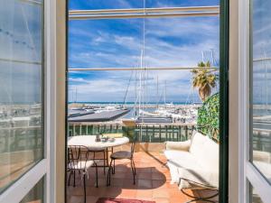 een balkon met een tafel en stoelen en uitzicht op een haven bij Apartment Ponente N-2 by Interhome in San Vincenzo