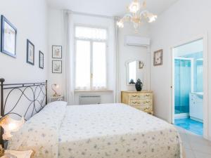 a white bedroom with a bed and a mirror at Apartment Ponente N-2 by Interhome in San Vincenzo