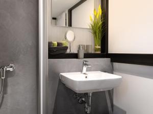 y baño con lavabo blanco y espejo. en Holiday Home Tiny Haus Westerwald 16 Blue by Interhome en Bad Marienberg