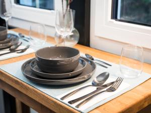 uma mesa com pratos, garfos, colheres e copos em Holiday Home Tiny Haus Westerwald 16 Blue by Interhome em Bad Marienberg