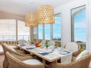 Un comedor con mesa y sillas y ventanas. en Villa Panorama-1 by Interhome, en Lloret de Mar