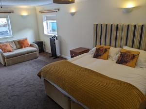 a bedroom with a large bed and a couch at sorn inn holiday apartments in Sorn