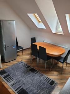 a dining room with a table and chairs and a refrigerator at 3 Zimmer Wohnung für 6 Personen in Gößnitz