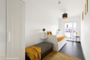 1 dormitorio con paredes blancas y 1 cama con sábanas amarillas en Pineapple Apartments Dresden Zwinger VI - 98 qm - 1x free parking en Dresden