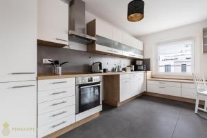 a kitchen with white cabinets and a window at Pineapple Apartments Dresden Zwinger VI - 98 qm - 1x free parking in Dresden
