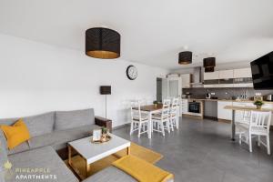 un soggiorno e una cucina con divano e tavolo di Pineapple Apartments Dresden Zwinger VI - 98 qm - 1x free parking a Dresda