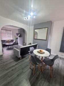 a living room with a table and chairs and a couch at Lovely 2-bedroom house close to Media City. in Manchester