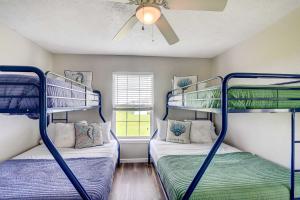 2 Etagenbetten in einem Zimmer mit Deckenventilator in der Unterkunft Charming Galveston Vacation Rental Walk to Beach! in Galveston