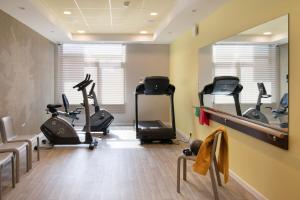 a gym with treadmills and exercise bikes in a room at LE JARDIN D'EDO in Mulhouse