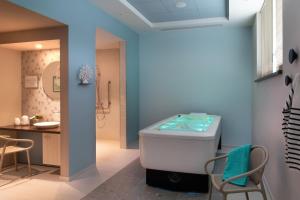 a bathroom with a bath tub and a sink at LE JARDIN D'EDO in Mulhouse