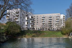 an apartment building next to a body of water at LE JARDIN D'EDO in Mulhouse