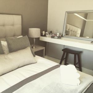 a bedroom with a bed and a large mirror at BoKáro Boutique Guesthouse in Prieska