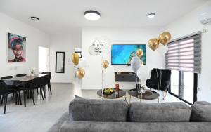 a living room with a couch and a table with balloons at אחוזת העמק סוויטות בפוריה in Poriyya Illit