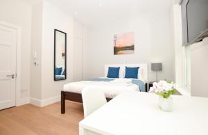 um quarto branco com 2 camas e um espelho em Fitzroy Serviced Apartments by Concept Apartments em Londres