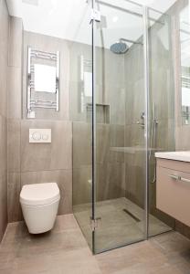 uma casa de banho com um chuveiro, um WC e um lavatório. em Fitzroy Serviced Apartments by Concept Apartments em Londres