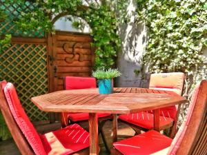 a wooden table with chairs and a potted plant on it at Hôtel La Marisa Grande Plage in Saint-Jean-de-Luz