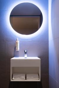 a bathroom with a white sink and a mirror at Zedwell Underground Tottenham Court Rd in London