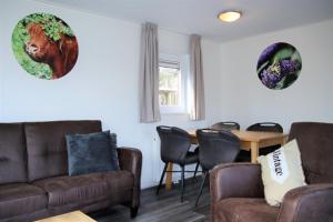 a living room with two couches and a table at Chalet Merel in Drijber