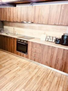 - une cuisine avec des placards en bois et un comptoir dans l'établissement River House Transylvania, à Frăsinet